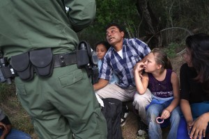 Agente de partulla fronteriza habla con inmigrante con hijos